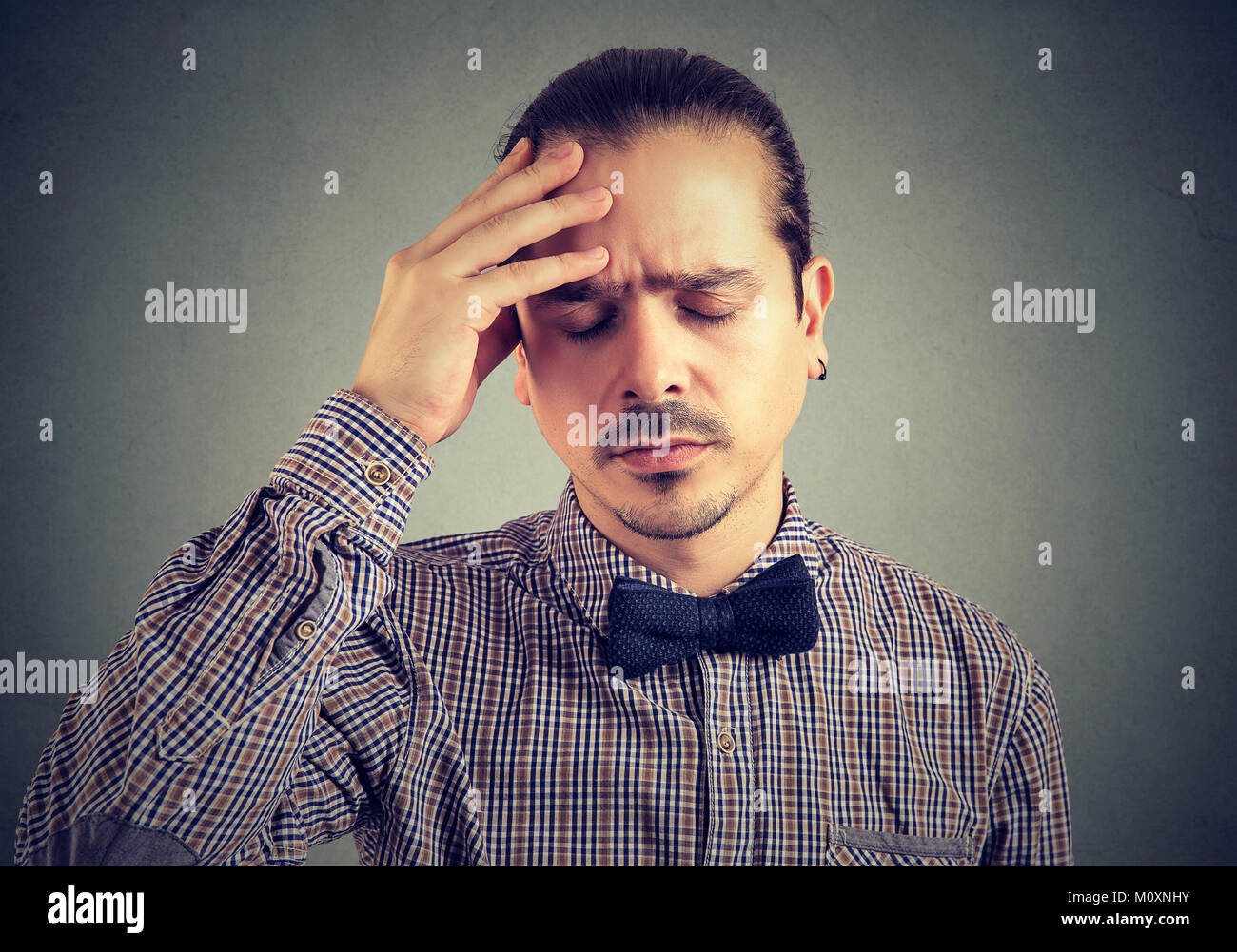 Young elegant man rubbing head having expression of pain and street. Stock Photo