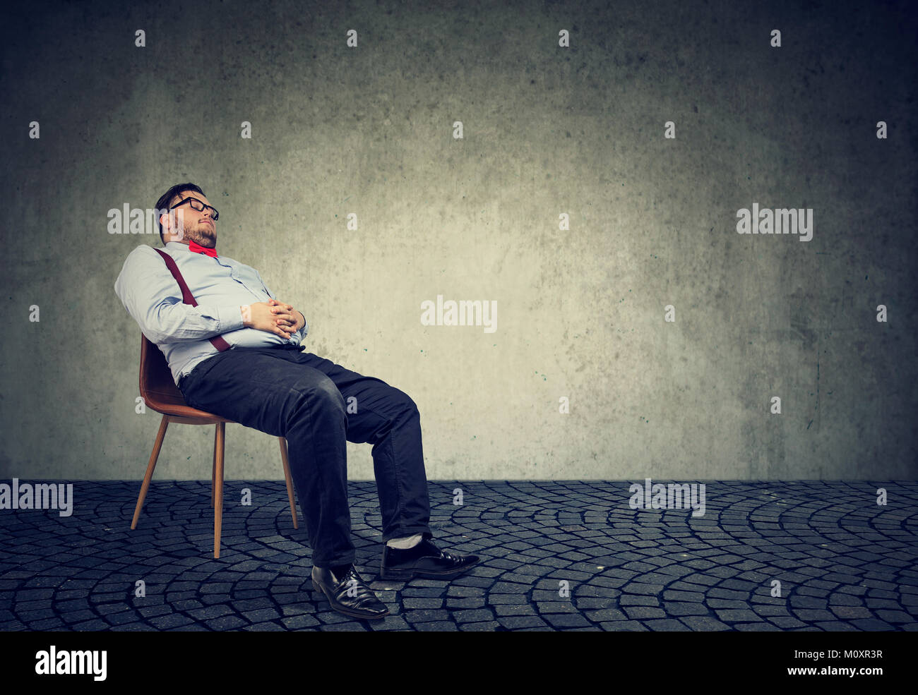 Fat man in formal clothing sitting on chair and sleeping in dream. Stock Photo