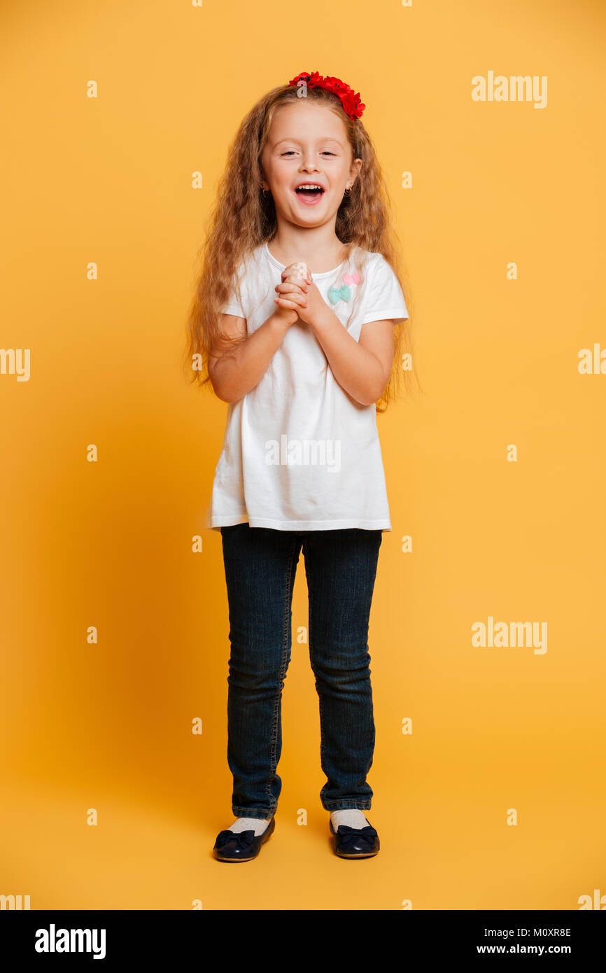 Image of cute surprised little girl child standing isolated over yellow ...
