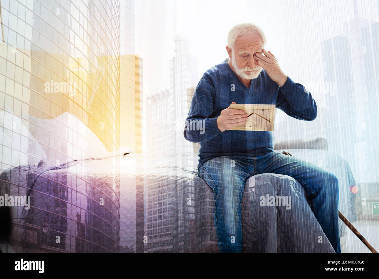 Old Person Crying While Looking At The Photo In His Hands Stock