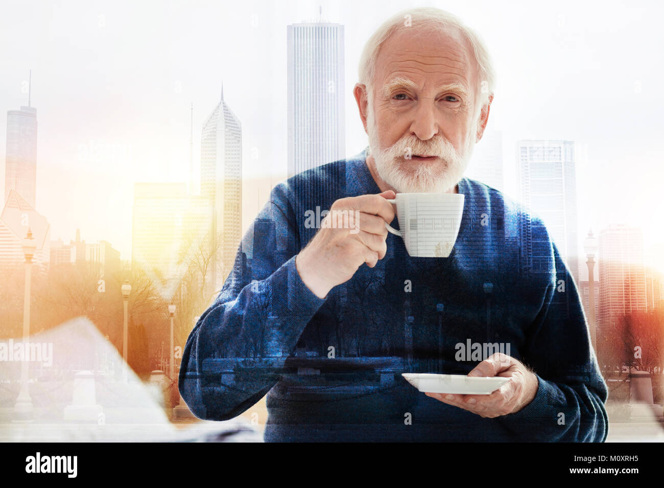 Senior person looking thoughtful while drinking coffee Stock Photo