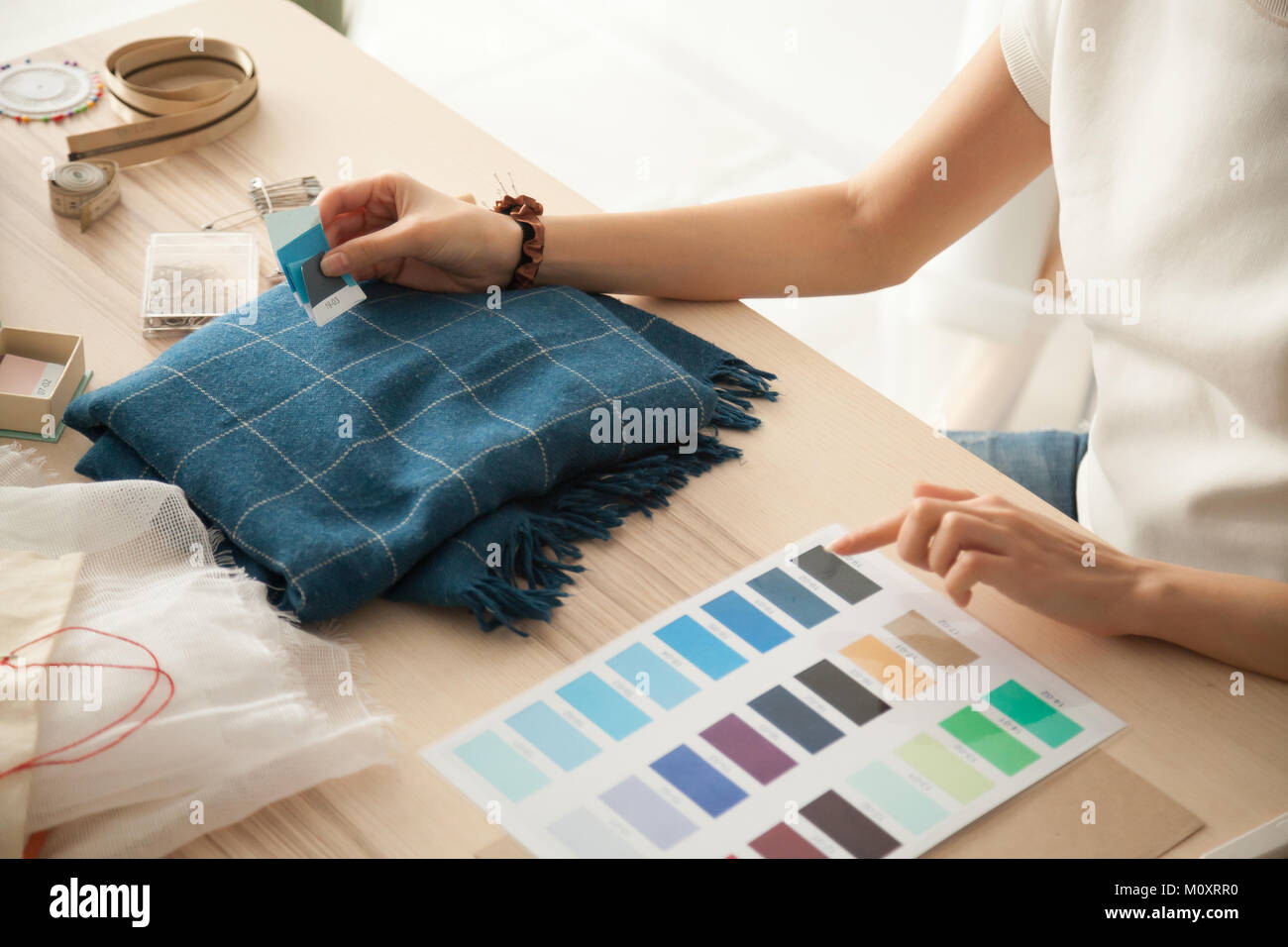 Female fashion designer holding samples choosing color working w Stock Photo