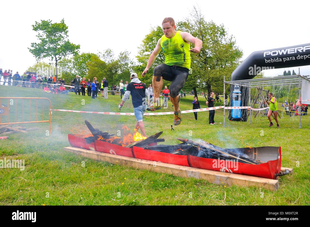 OVIEDO, SPAIN - MAY 9: Storm Race, an extreme obstacle course in May 9, 2015 in Oviedo, Spain. Runners jumping a barrier of fire. Stock Photo