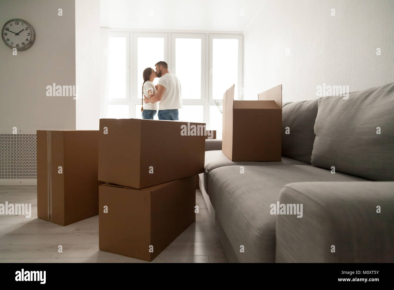 Cardboard boxes with kissing couple at background, moving day co Stock Photo