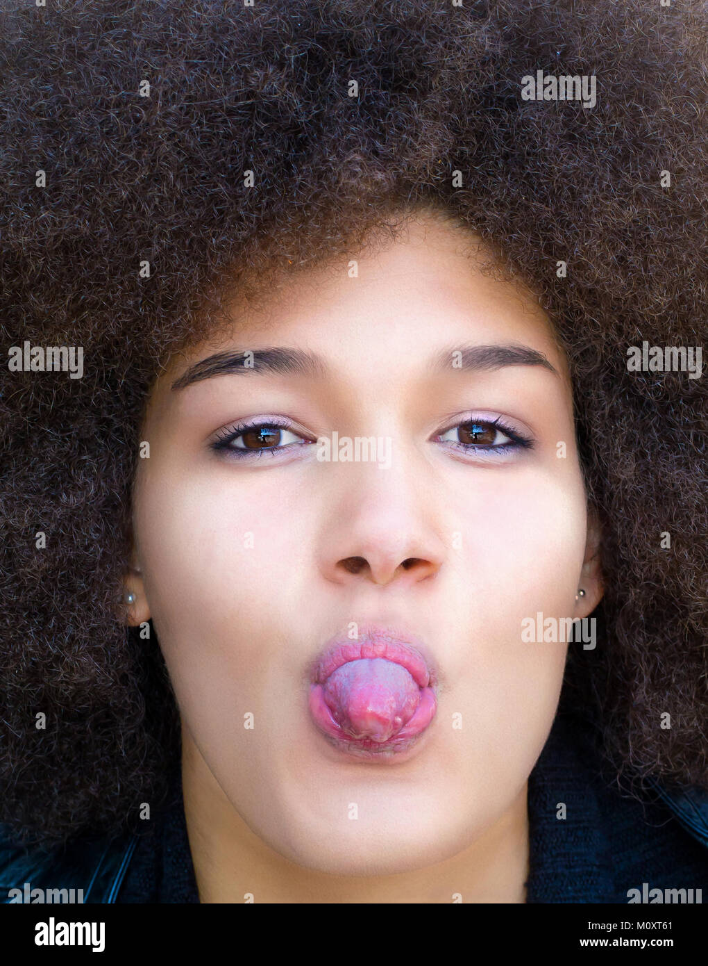Young afro woman sticking tongue out Stock Photo