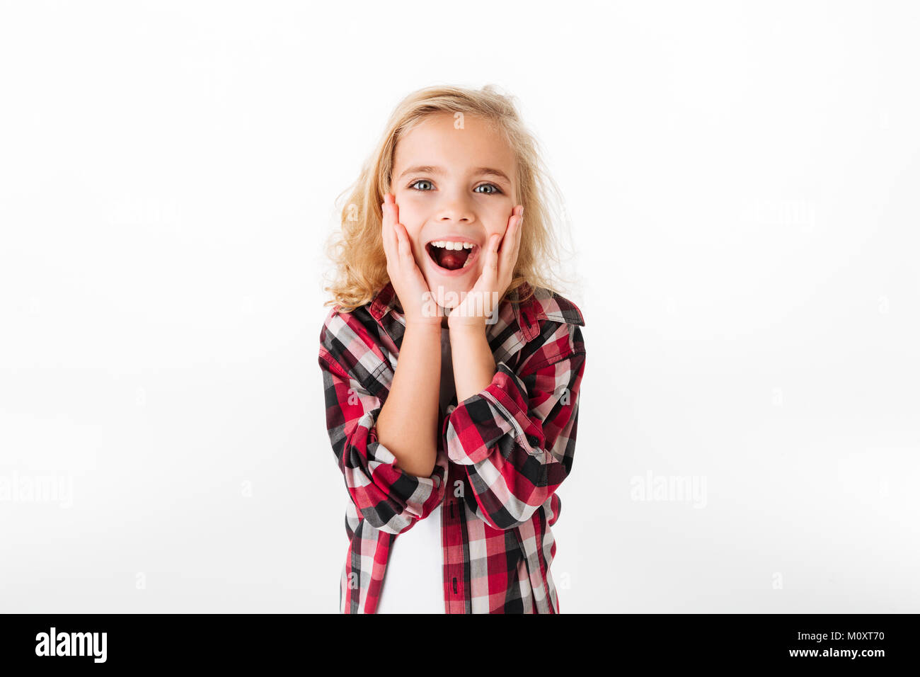 Portrait of a happy little girl holding hands at her face and looking ...