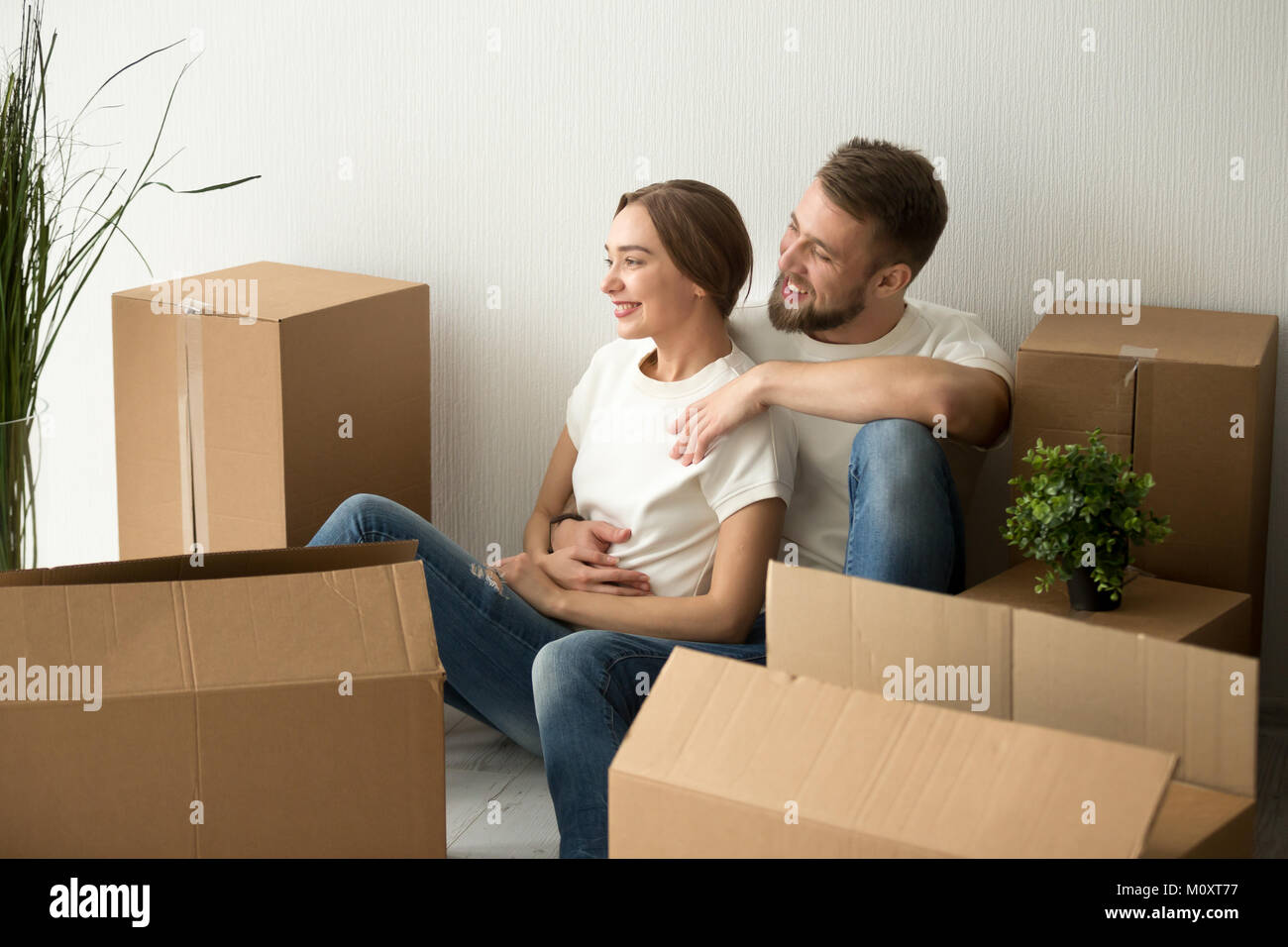 Young couple embracing looking forward to future in new home Stock Photo