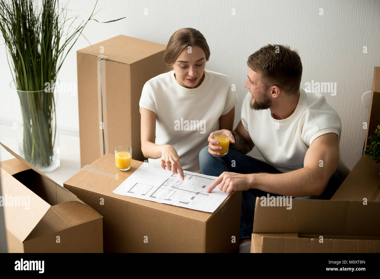 Couple agreeing on home interior design with house plan together Stock Photo