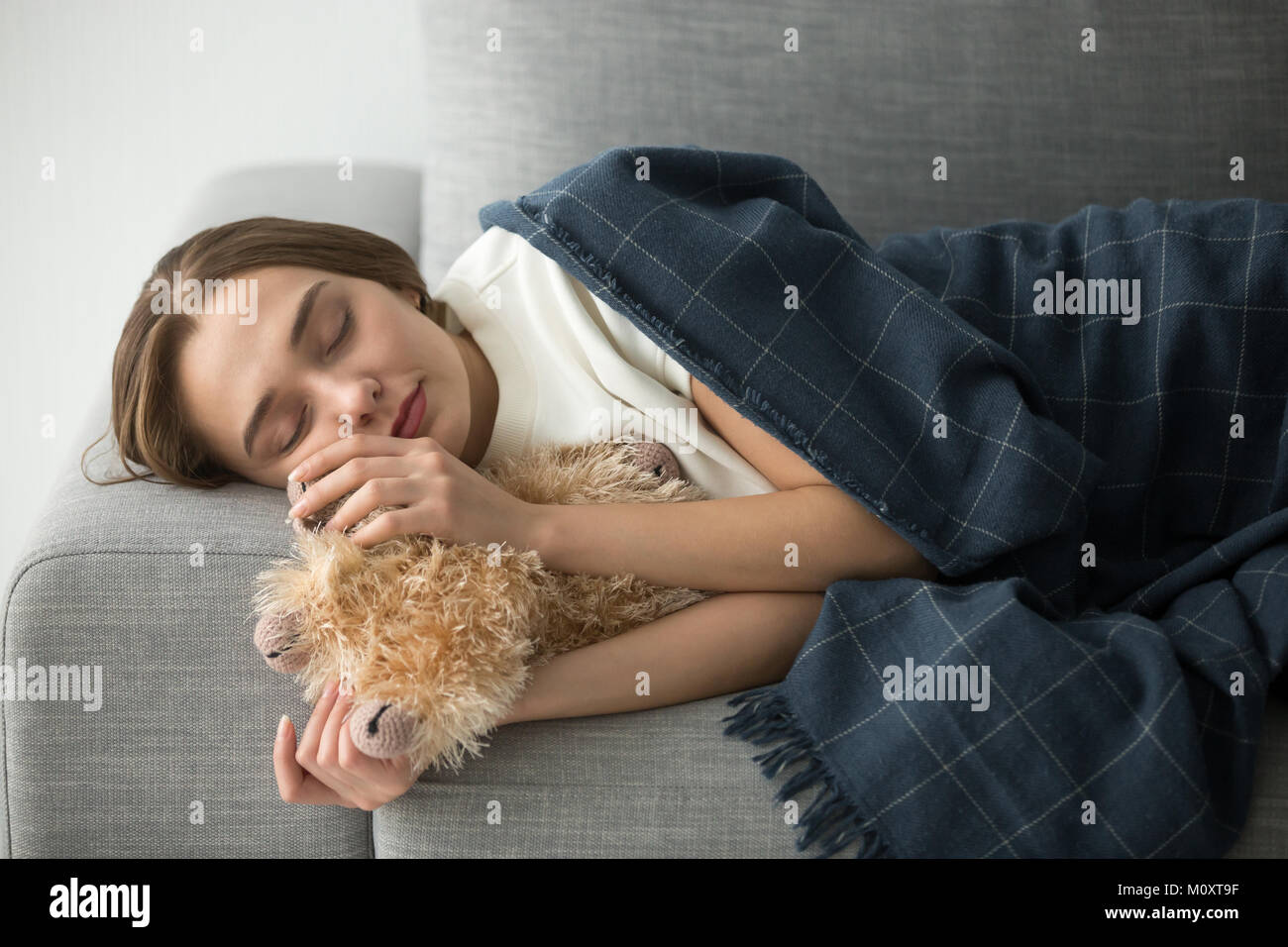 Childish woman sleeping on soft comfortable sofa with stuffed to Stock Photo