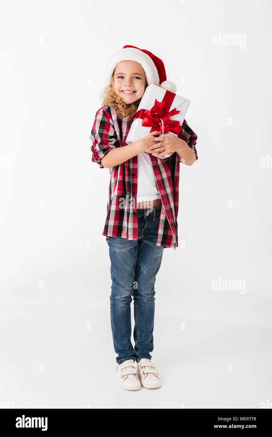 Full length portrait of a pretty little girl holding gift box and ...