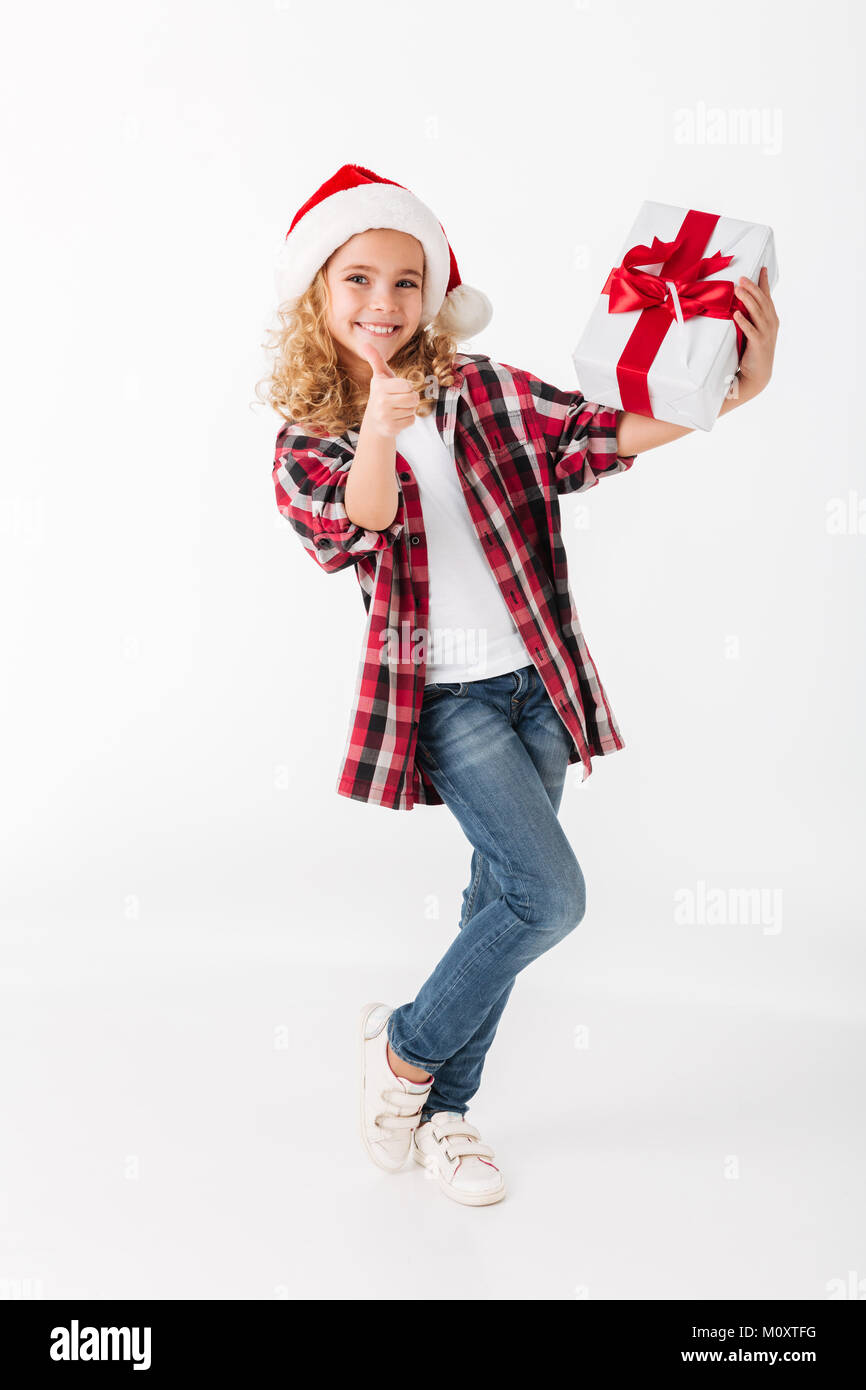 Full length portrait of a smiling little girl holding gift box and ...