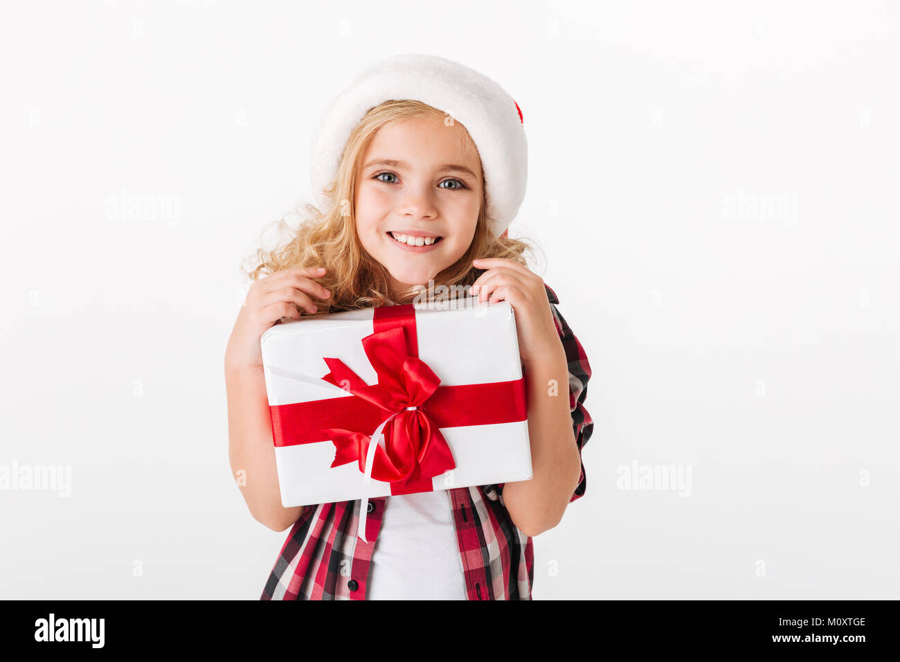 Portrait of a lovely little girl holding gift box and looking at camera ...