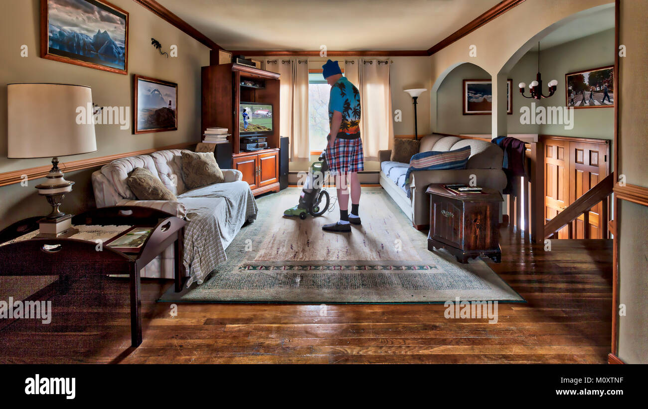 A bachelor man vacuuming the rug. Stock Photo