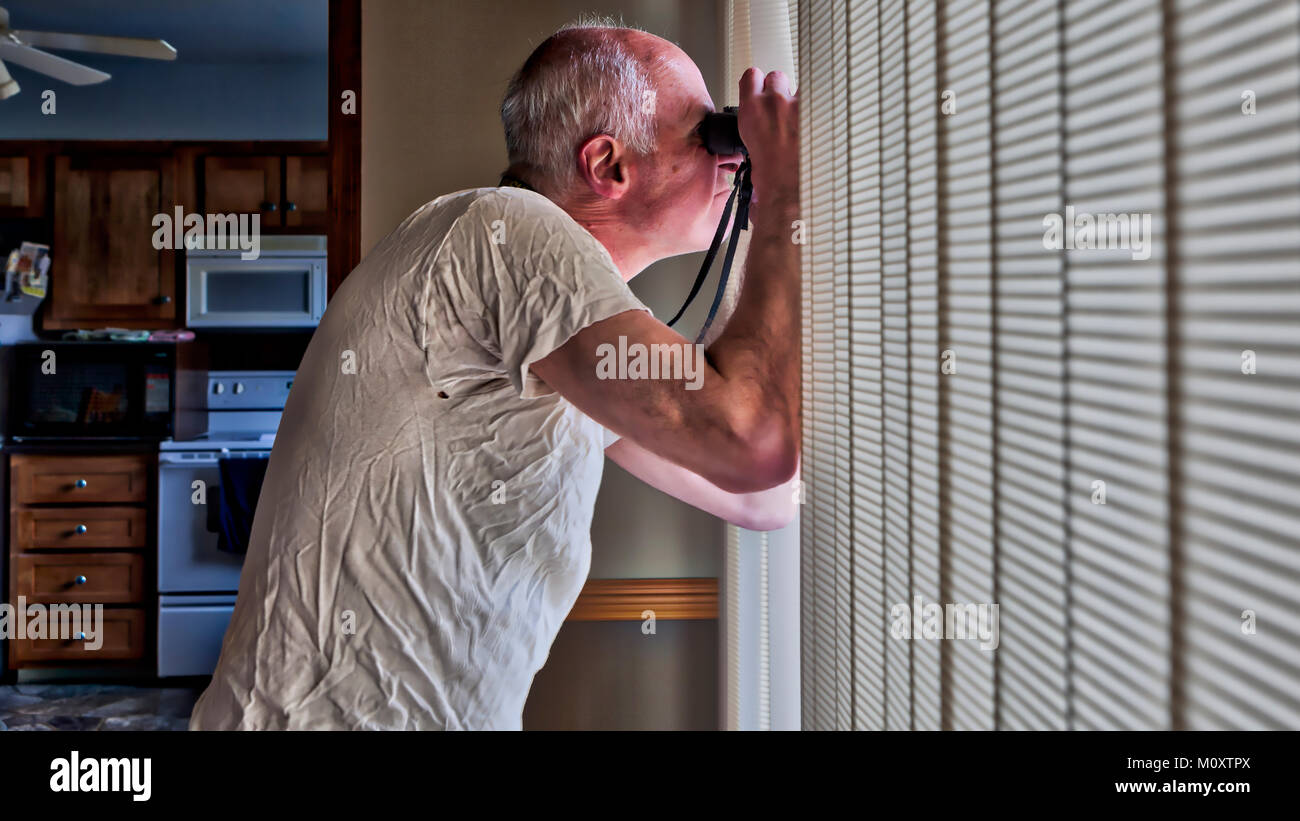 A bachelor man spying on his neighbors. Stock Photo