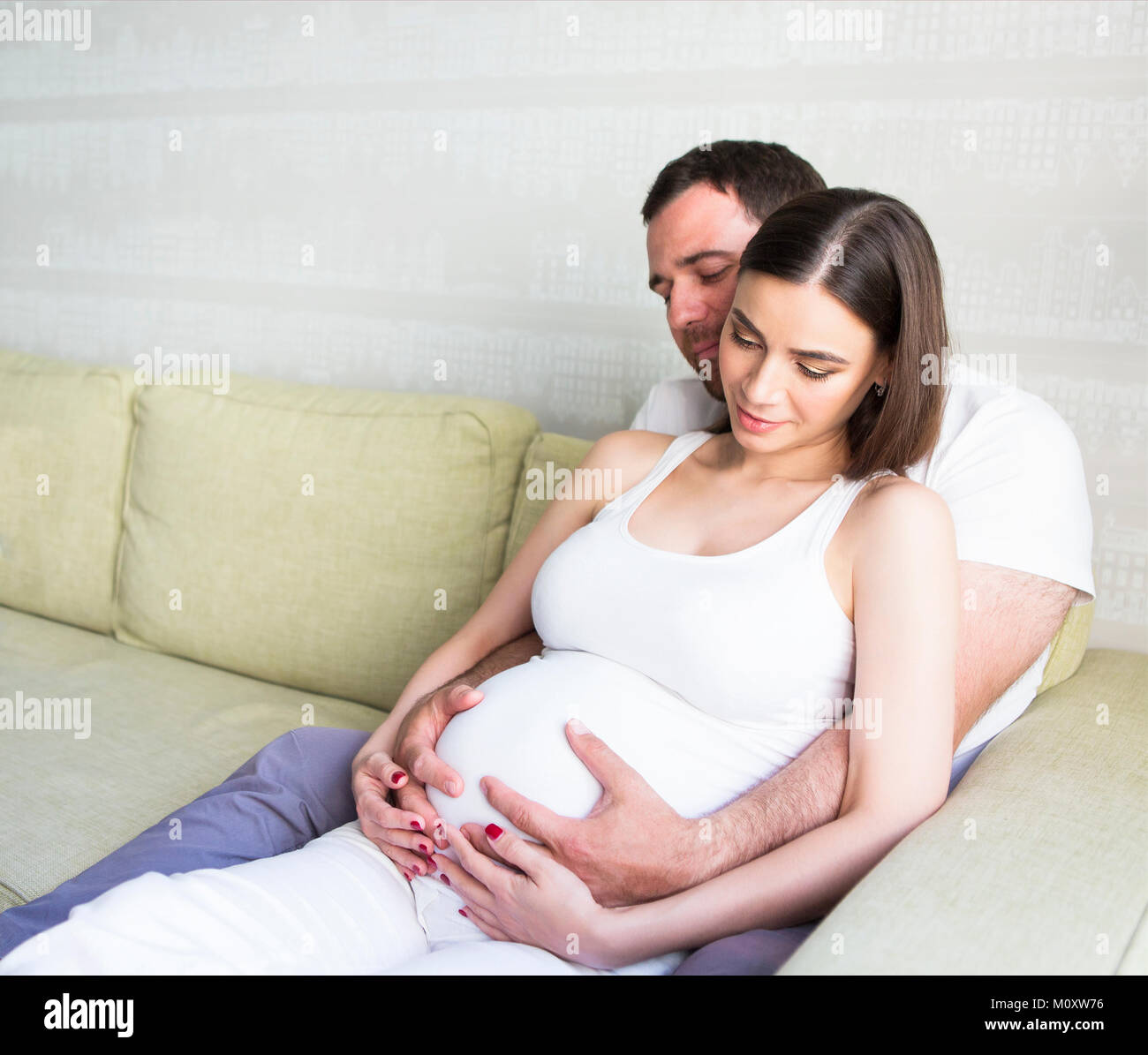 Pregnant woman and young man together indoors Stock Photo - Alamy