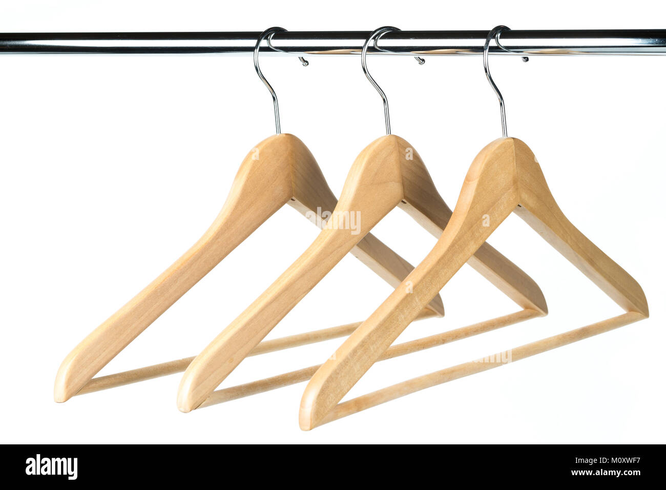 Three wooden coat / clothes hangers on a clothes rail with a white background. Potential copy space to the left of hangers. Stock Photo