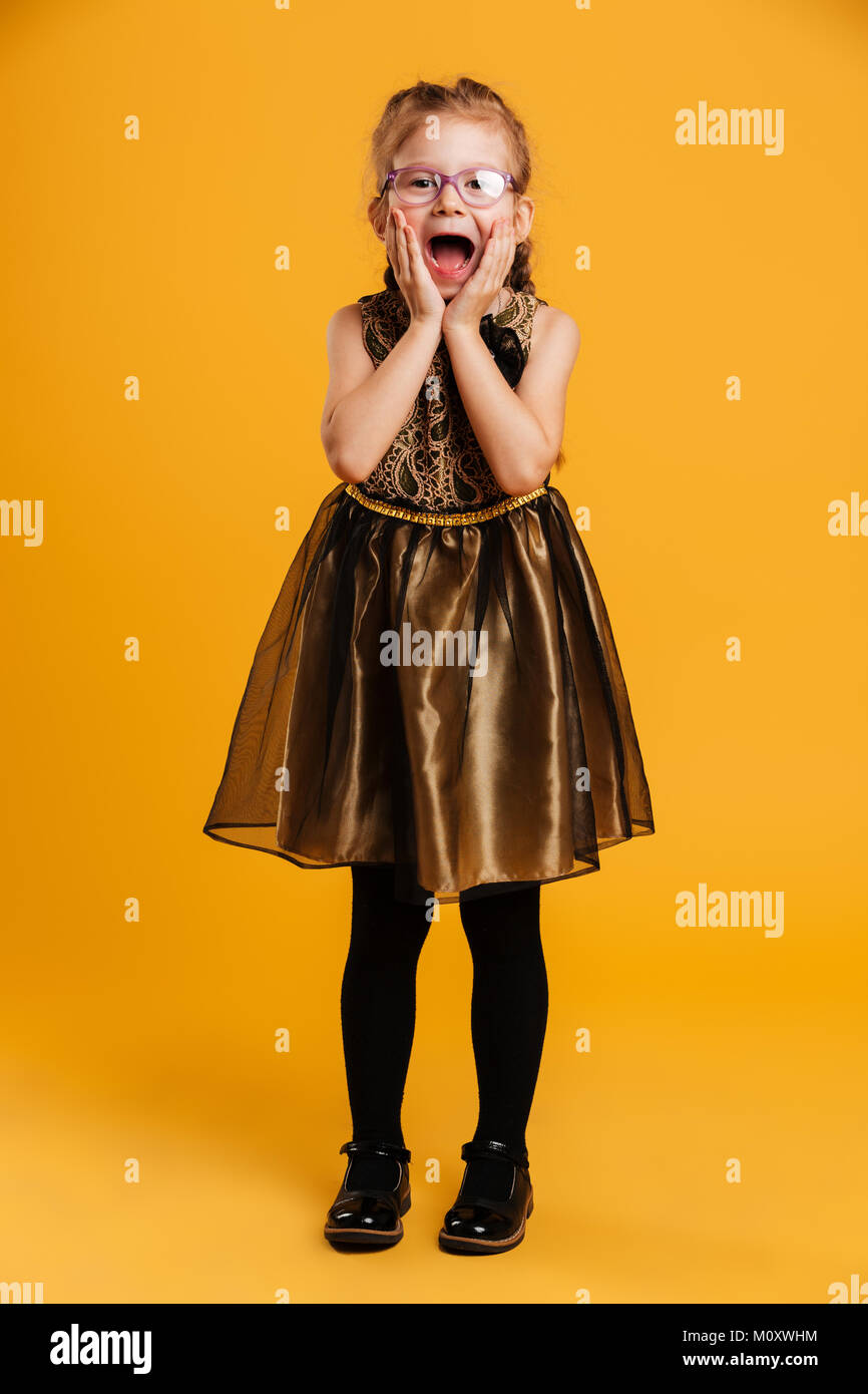 Photo of shocked little girl child standing isolated over yellow ...
