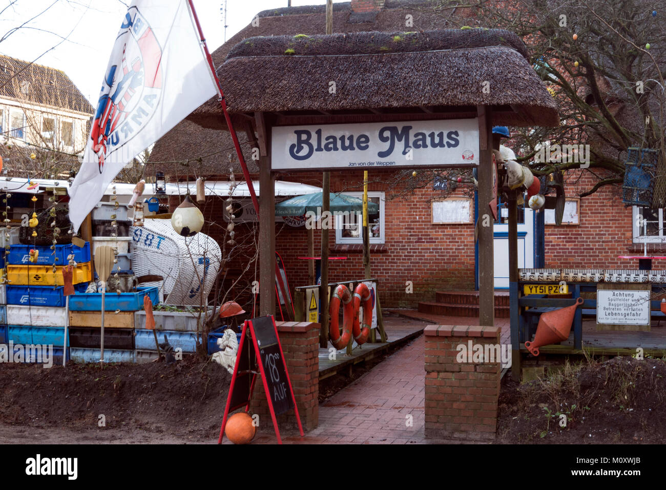 AMRUM, GERMANY - JANUARY 02, 2018: Fishing crates, buoys and other maritime objects in front of the old bar Blaue Maus on the North Frisian island Amr Stock Photo