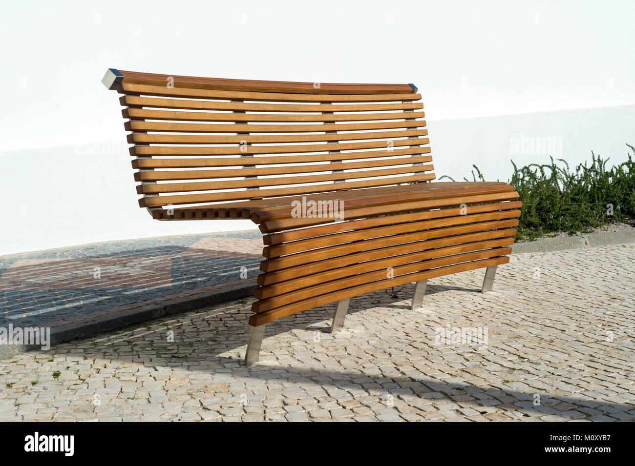 modern contemporary wooden park bench in sunlight Stock Photo