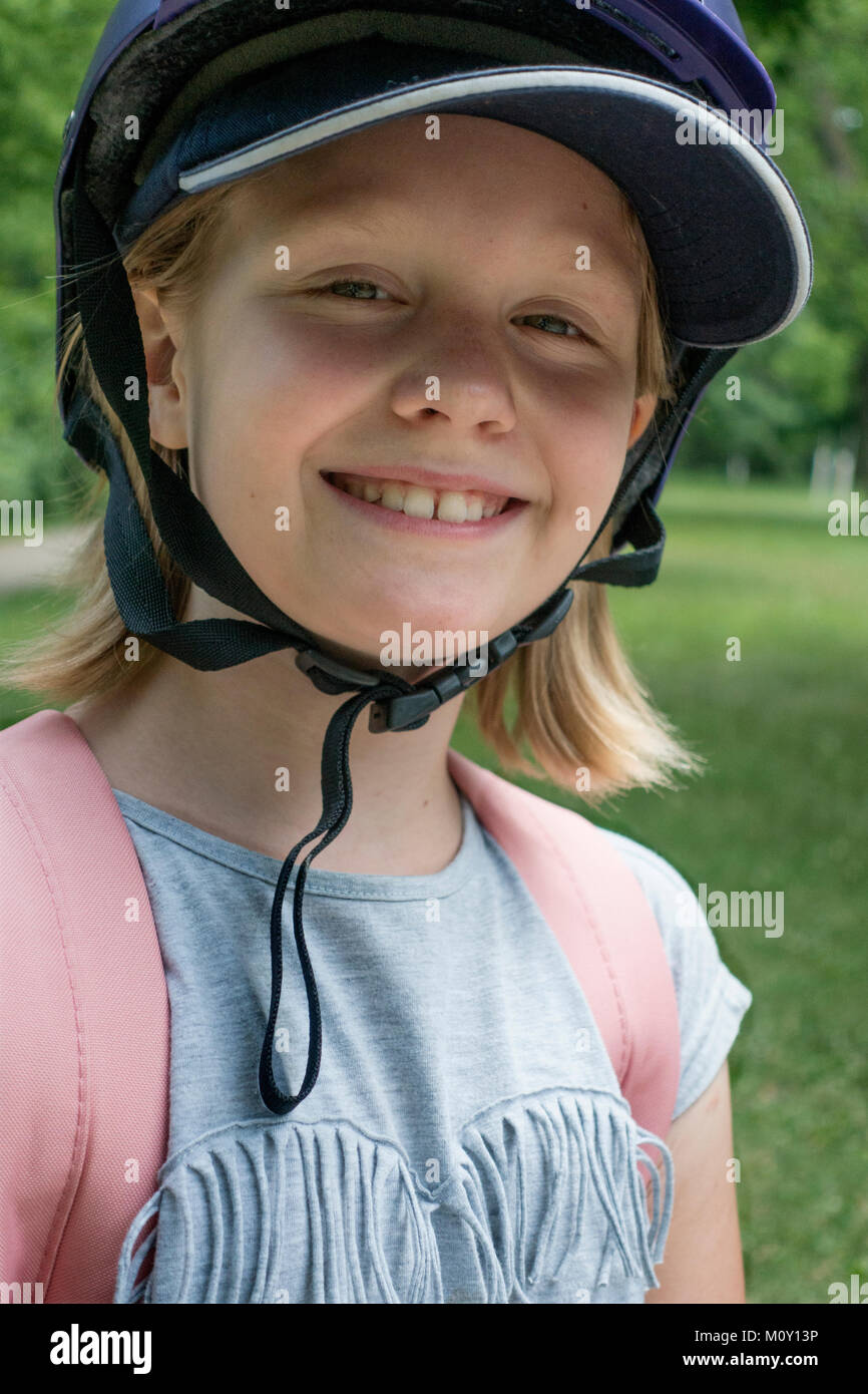 Happygolucky granddaughter wearing a safety helmet smiling during a