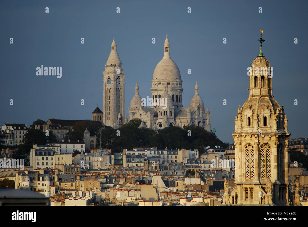 An amazing view of the Sacre Coeur with the Church of Saint Trinity in the foreground Stock Photo