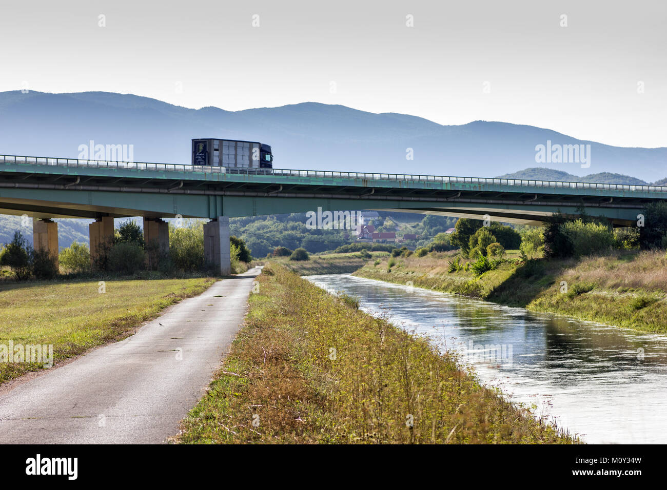 Lorry on the A1 highway viaduct  crossing a small side road and the river Gacka near Otocac, Croatia, 2017 Stock Photo