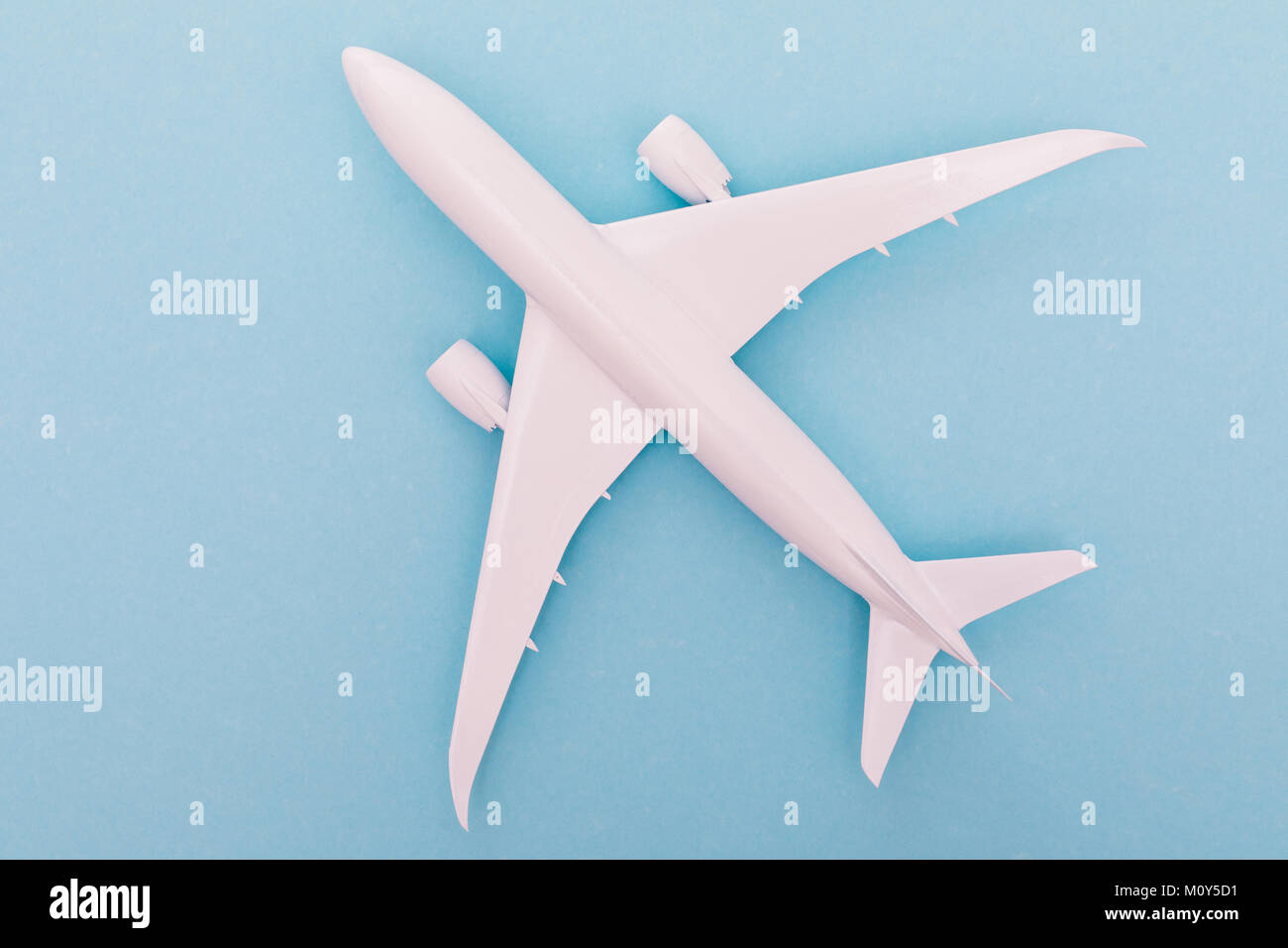 White toy plane on light blue background. Top view Stock Photo
