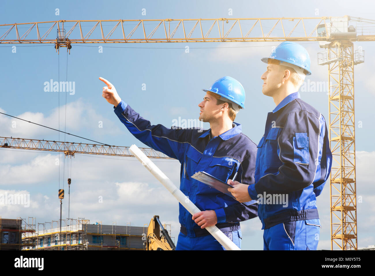 Two Young Male Architect Engineer Discussing At Construction Site Stock Photo