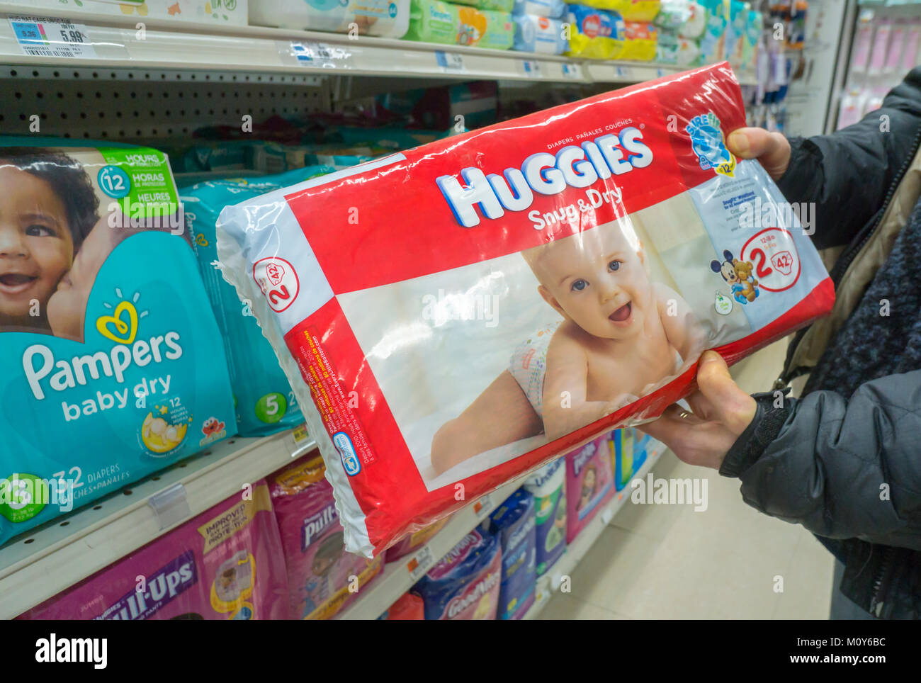A shopper chooses a package of Huggies brand disposable diapers by Kimberly-Clark in a supermarket in New York on Tuesday, January 23, 2018. Kimberly-Clark announced that it will cut 5000 jobs, 13 percent of its workforce, and close or sell 10 facilities in order to achieve $2 billion in reduced costs.  (Â© Richard B. Levine) Stock Photo