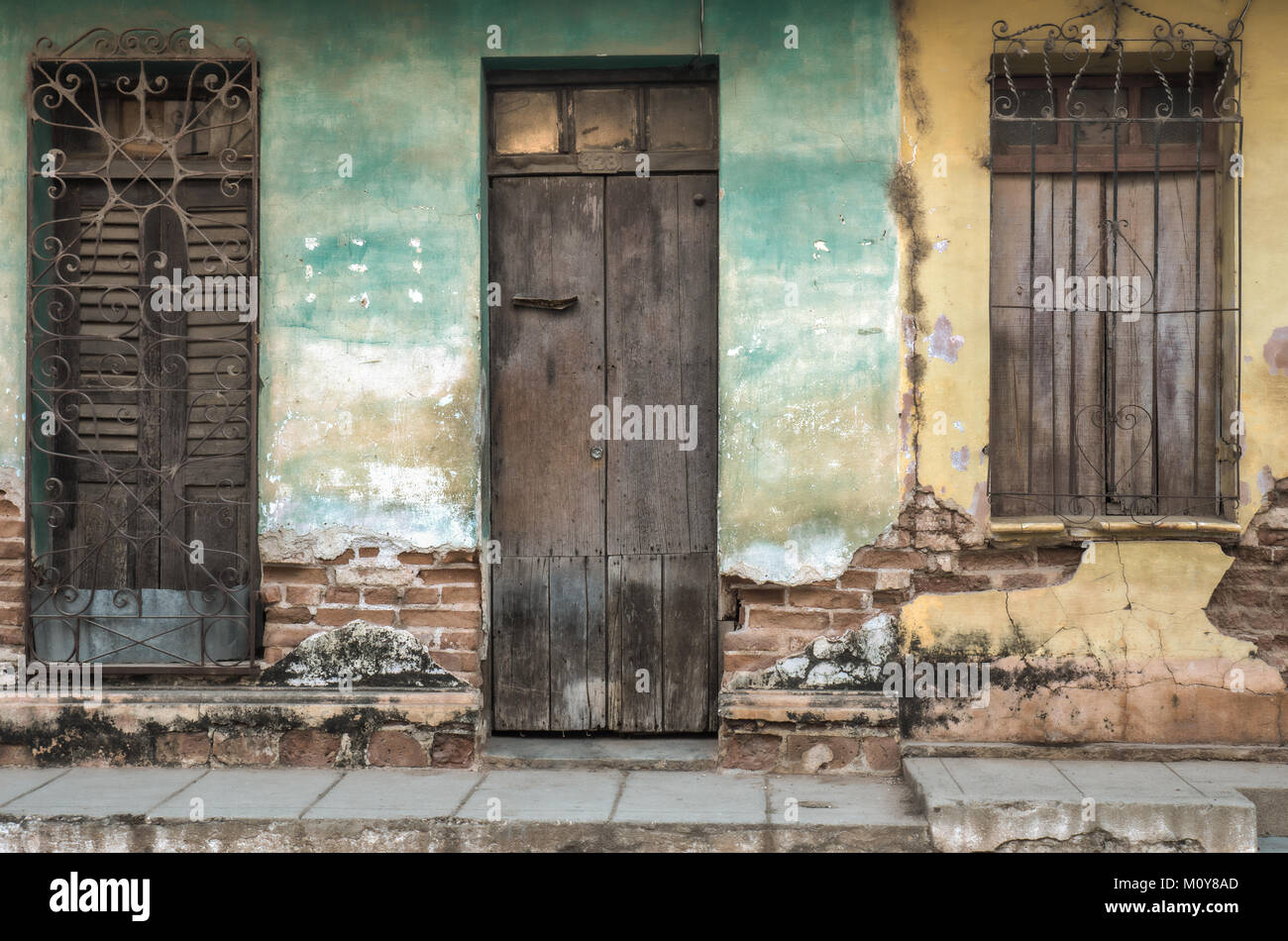 Blue and Yellow faded wall textures and old colonial buildings in Trinidad, Cuba Stock Photo