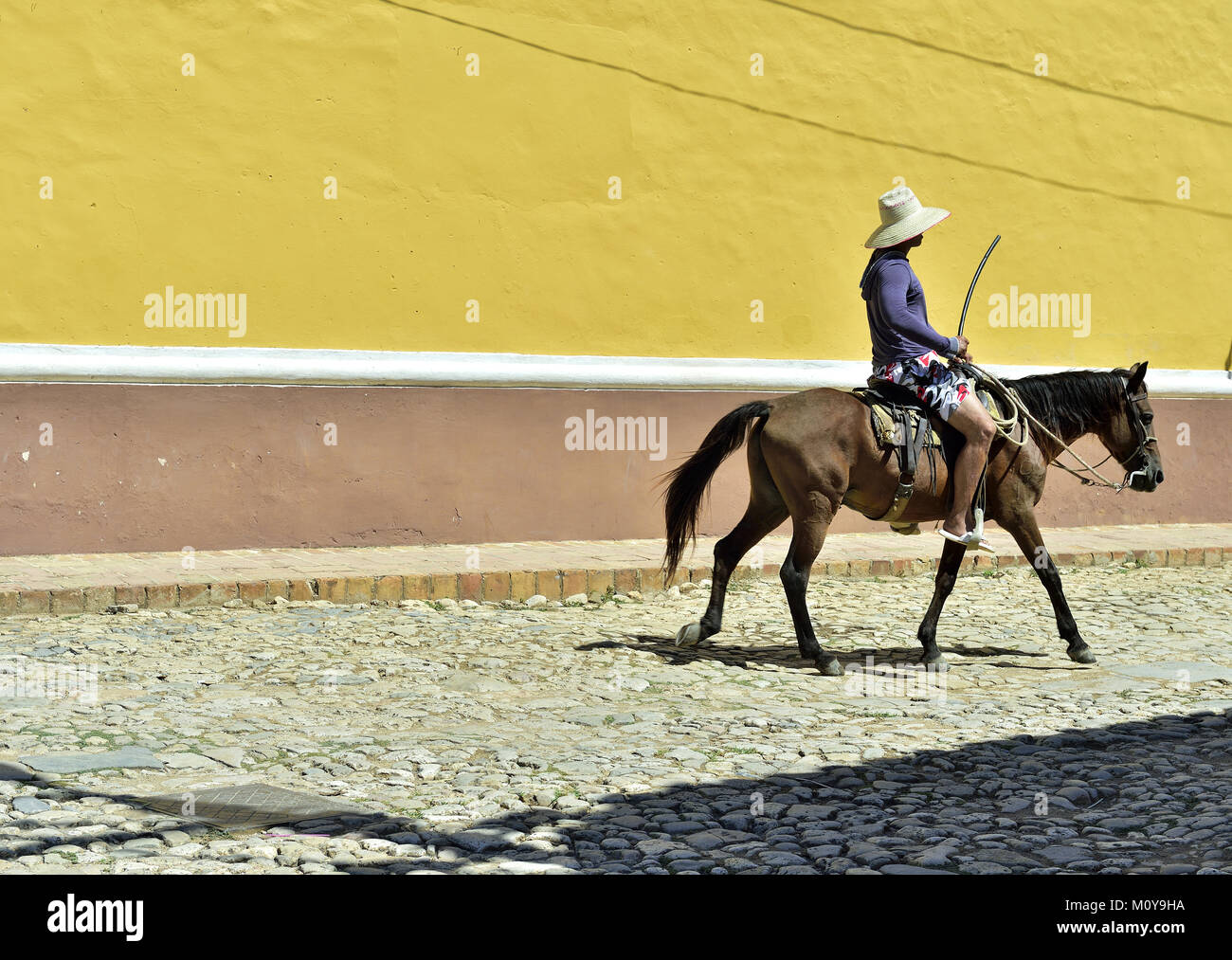 Cuban local man on horse on street in UNESCO protected city of Trinidad, Cuba. Stock Photo