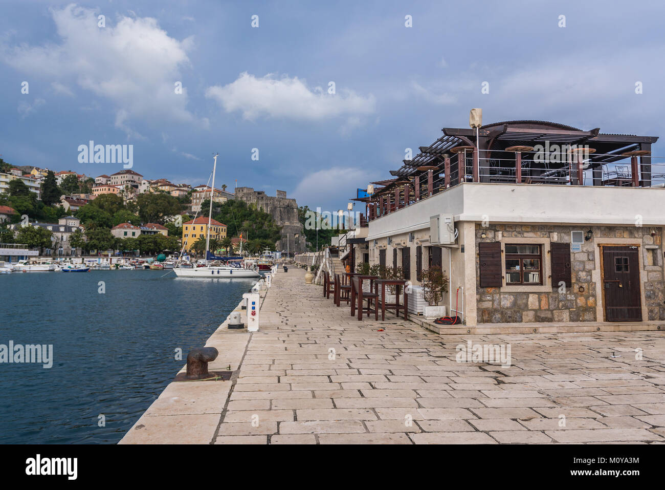 Admiral Cafe & Restaurant on a breakwater of Herceg Novi port on the Adriatic Sea coast in Montenegro. Forte Mare on background Stock Photo