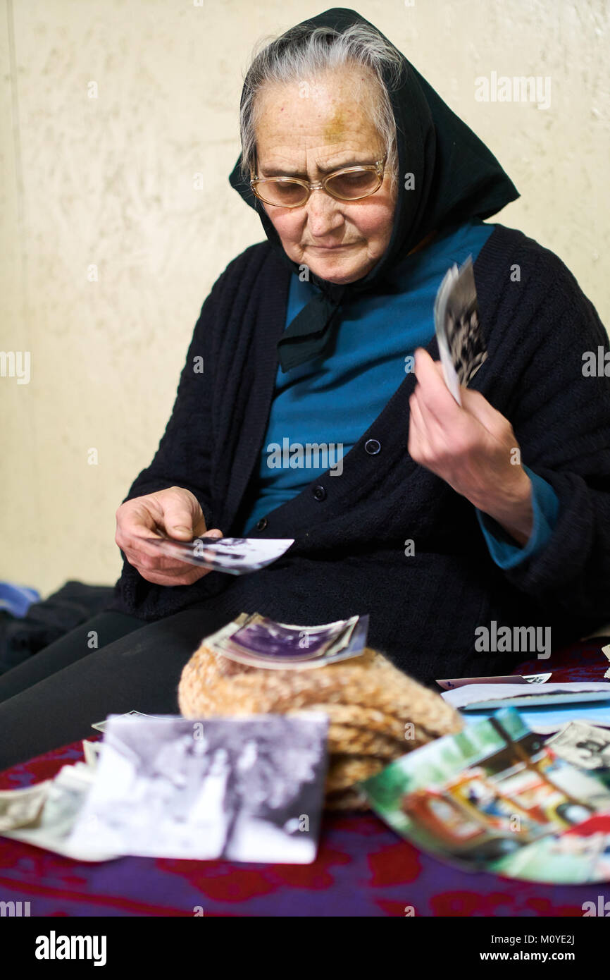 Senior woman looking at old photos indoor Stock Photo