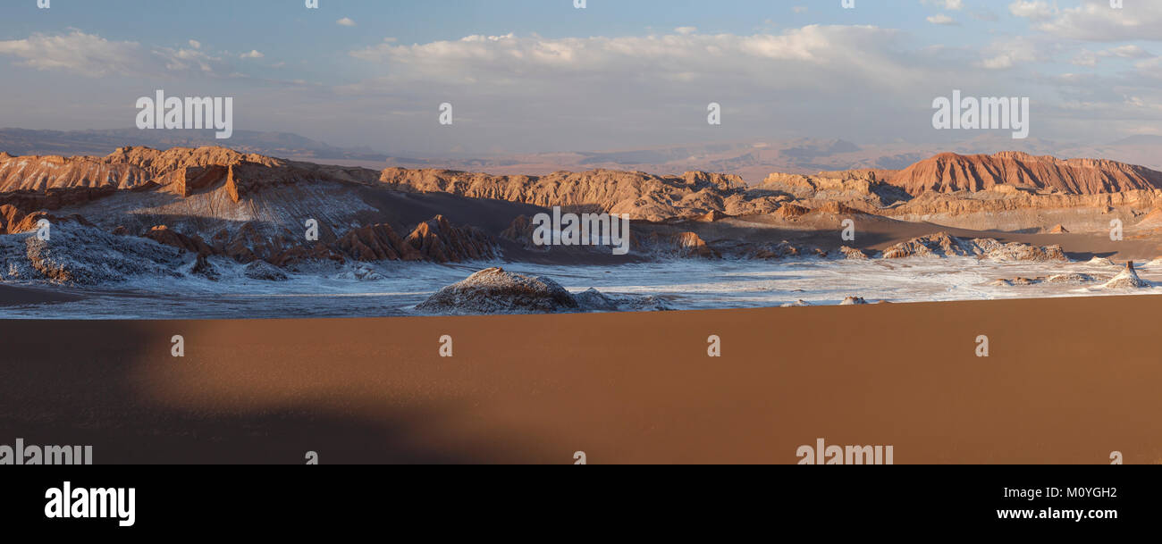 Giant dunes and bizarre red rock formations with white salt at sunset,Valle de la Luna,San Pedro de Atacama,Chile Stock Photo