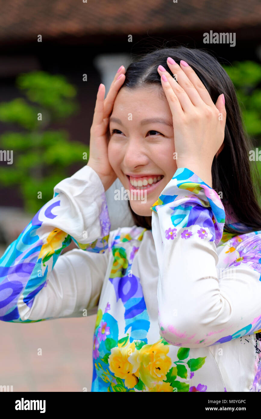 Vietnamese woman smiling and wearing a traditional Ao Dai dress Stock Photo