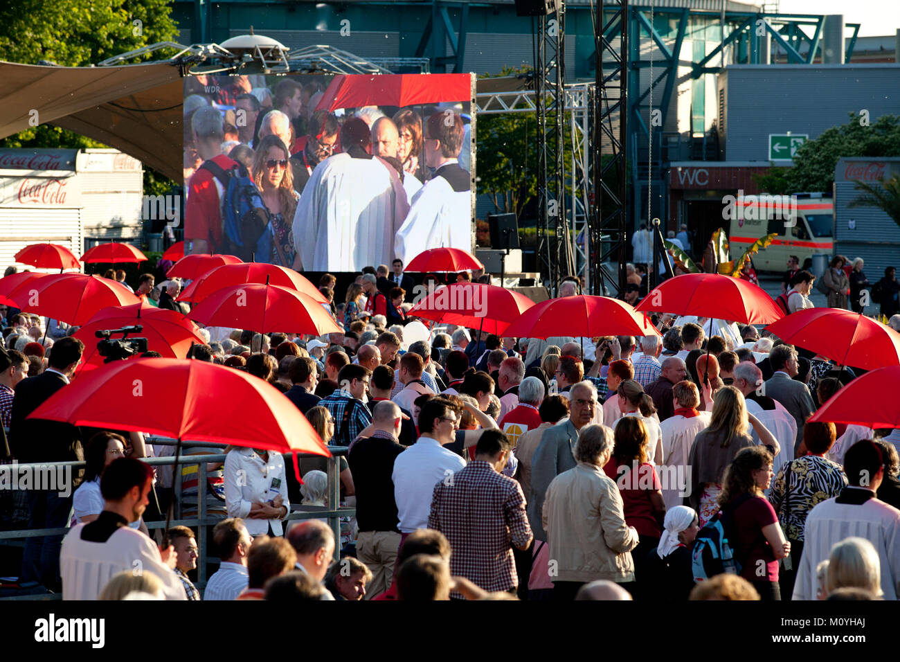 Germany, Cologne, opening worship of the Eucharistic Congress 2013 at the Tanzbrunnen in the district Deutz. With the red umbrellas the believers are  Stock Photo