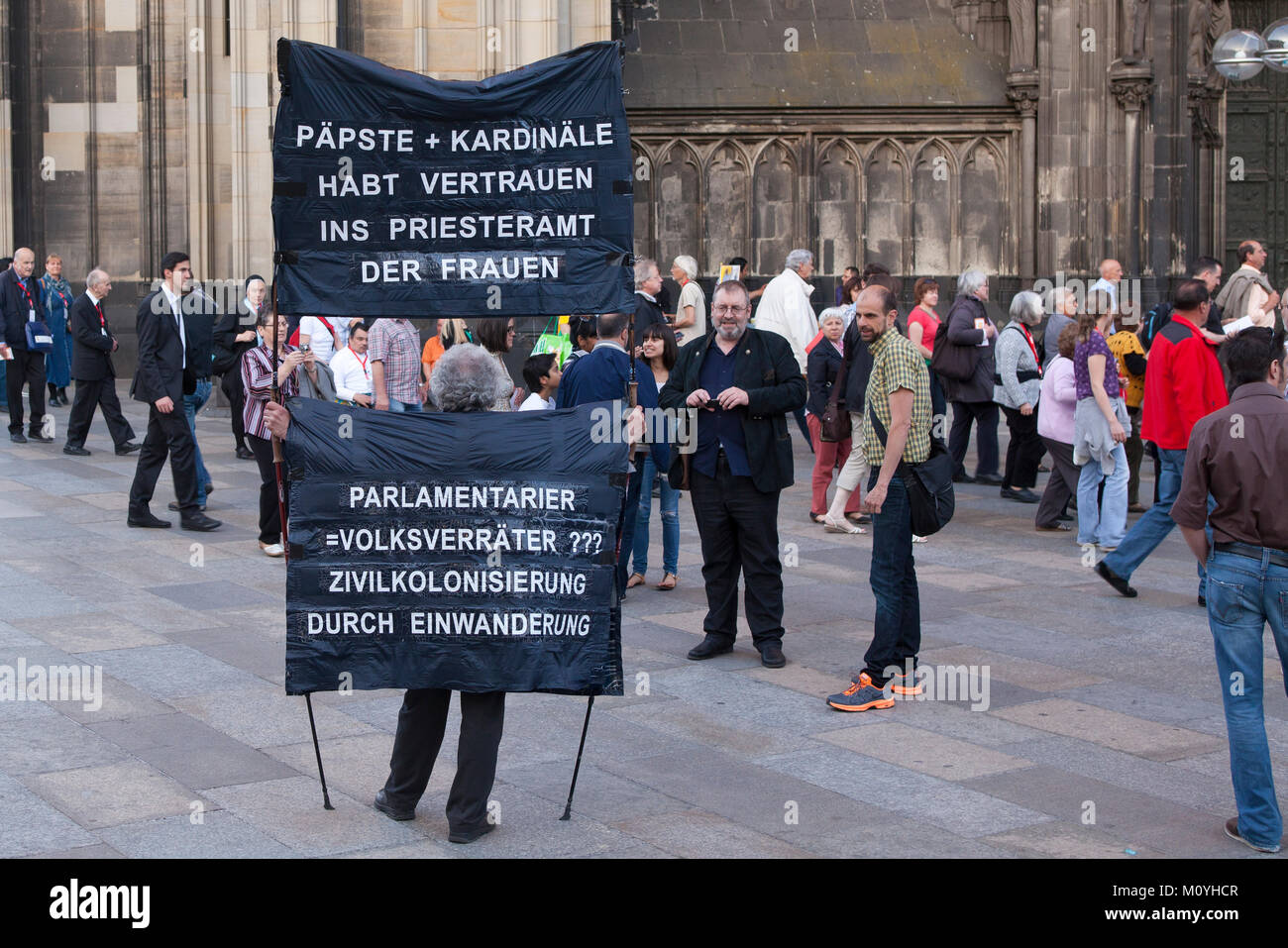 Germany, Cologne, demonstrator in front of the cathedral (translation: jesus wears wood. popes and cardinals wears gold and parliamentarians shameless Stock Photo