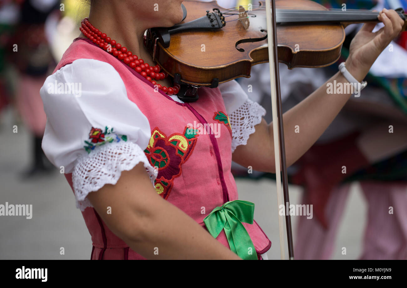 Polish woman is playing the violin with traditional costume Stock Photo