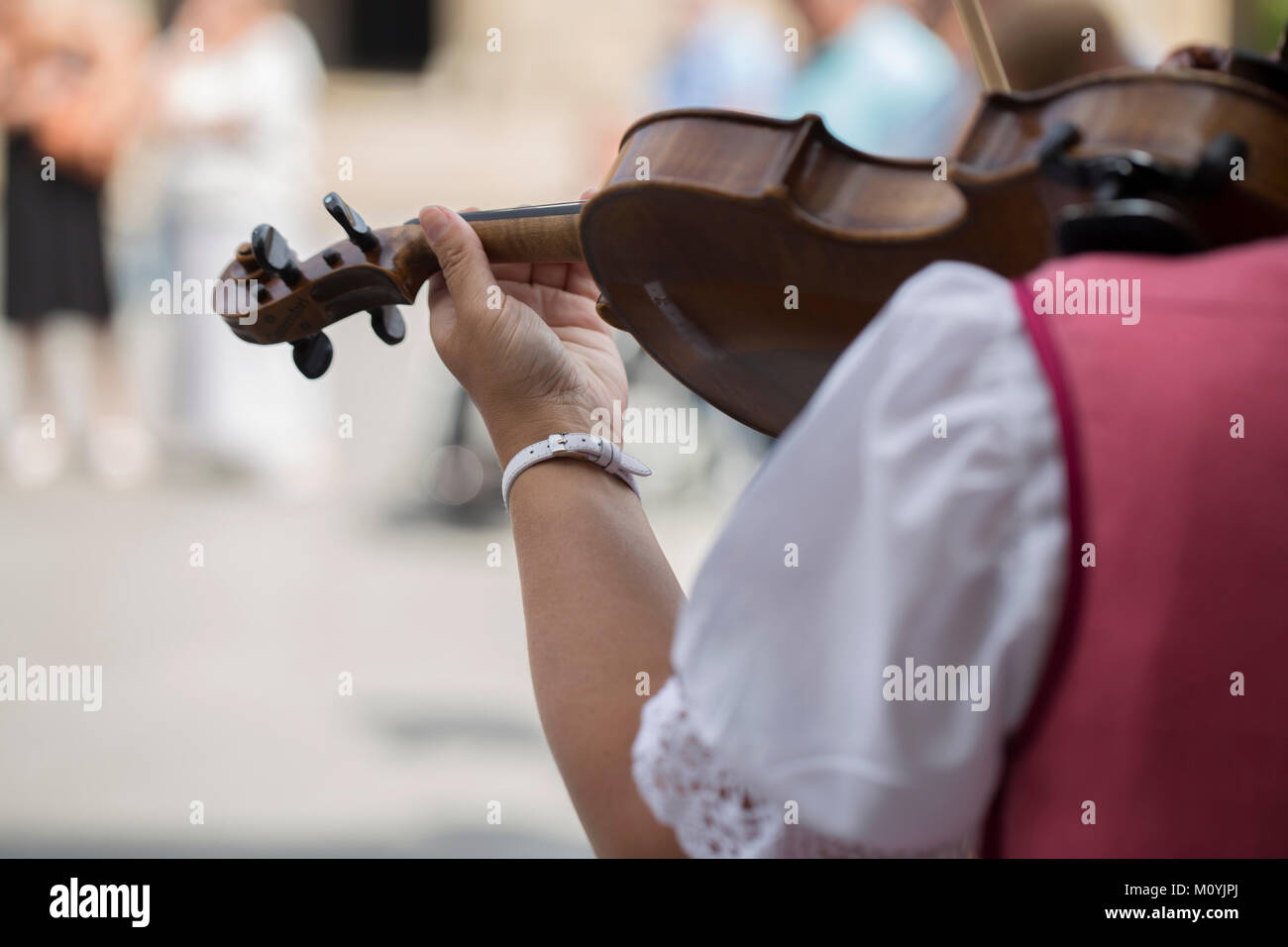 Rear view of a polish woman playing the violin with traditional costume Stock Photo
