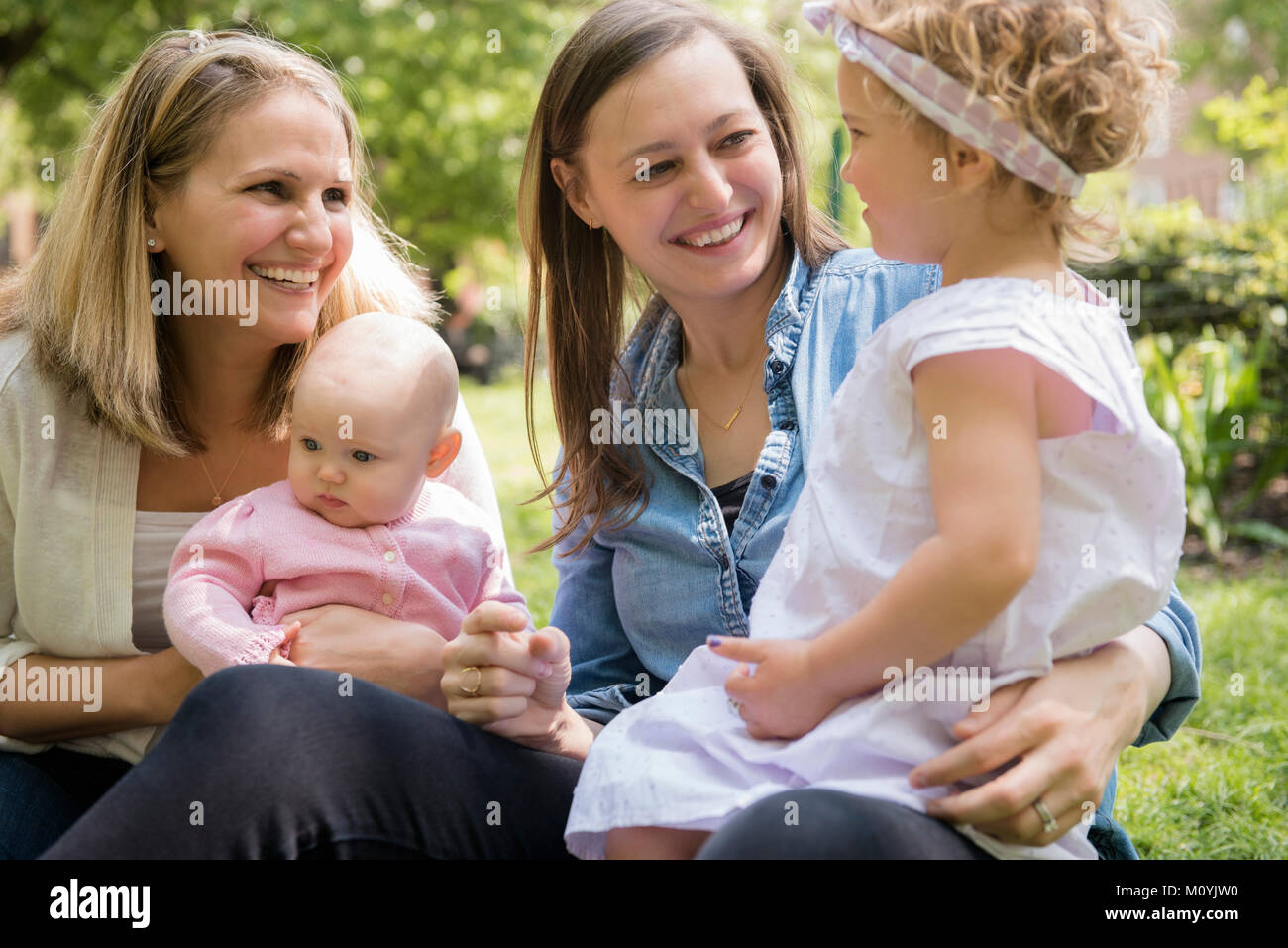 Caucasian mothers and daughters smiling in park Stock Photo
