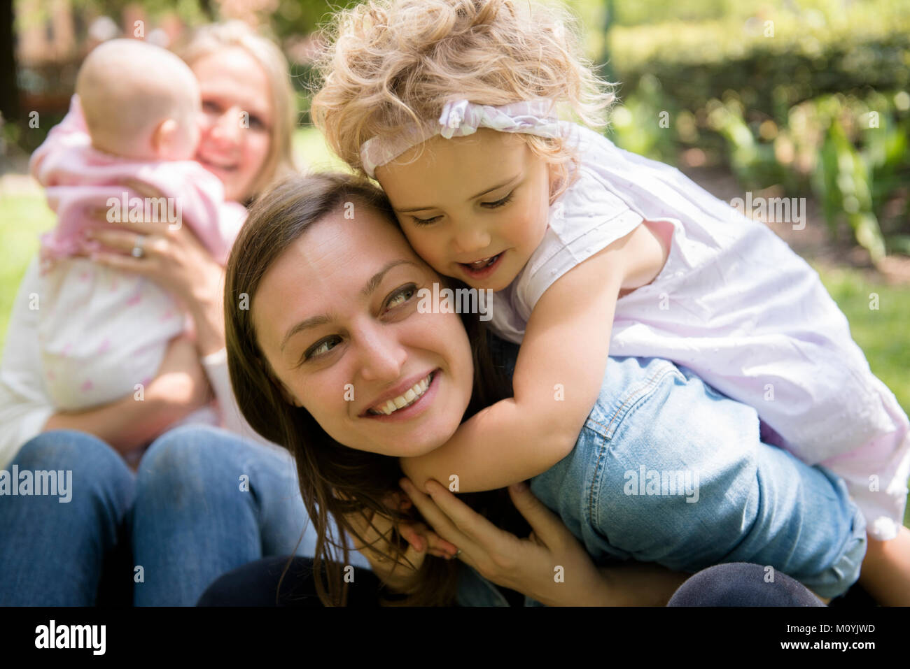 Caucasian girl hugging mother Stock Photo