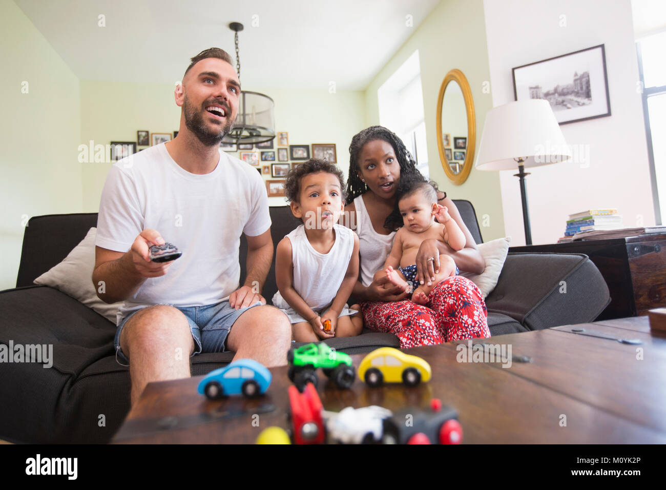 Parent watching television with son and daughter Stock Photo