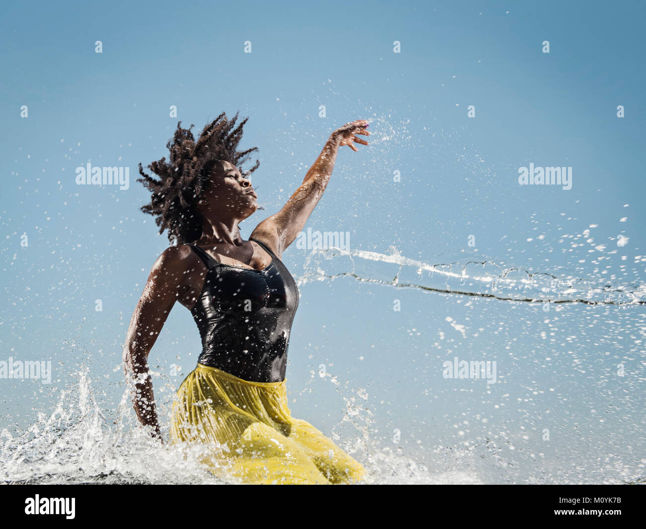 Water spraying on black woman dancing Stock Photo