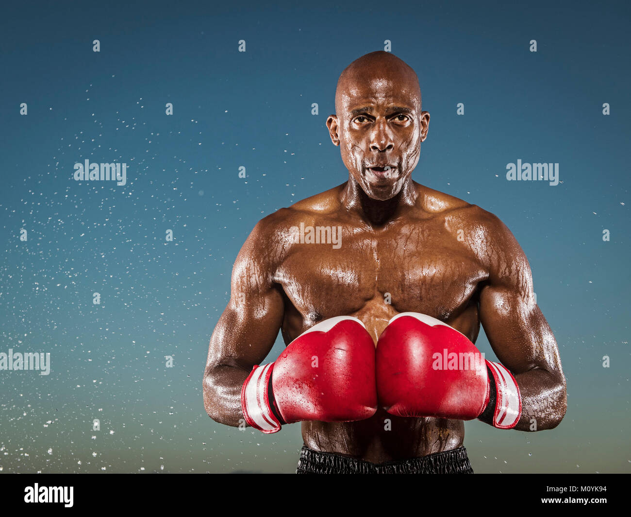 Water splashing on confident black boxer outdoors Stock Photo