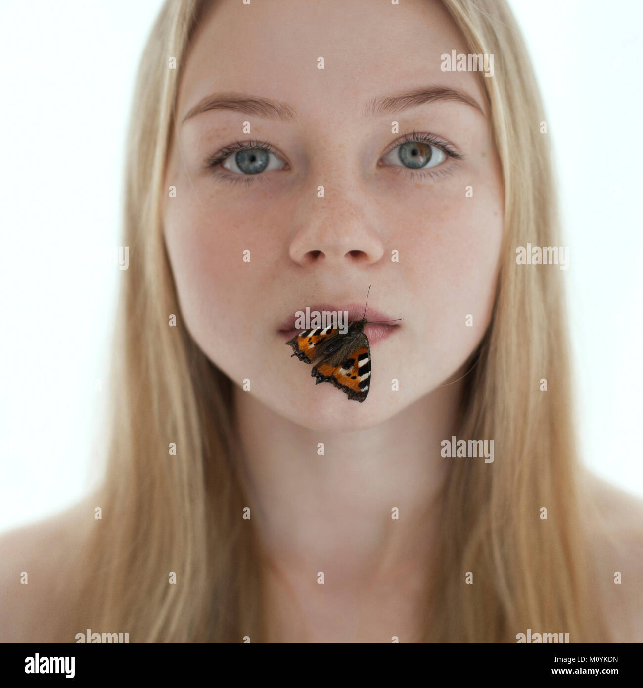 Butterfly on lips of Caucasian teenage girl Stock Photo