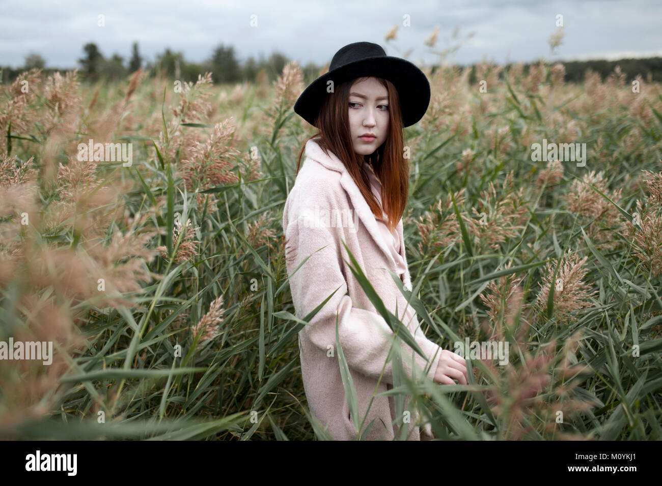 Asian woman standing in field Stock Photo
