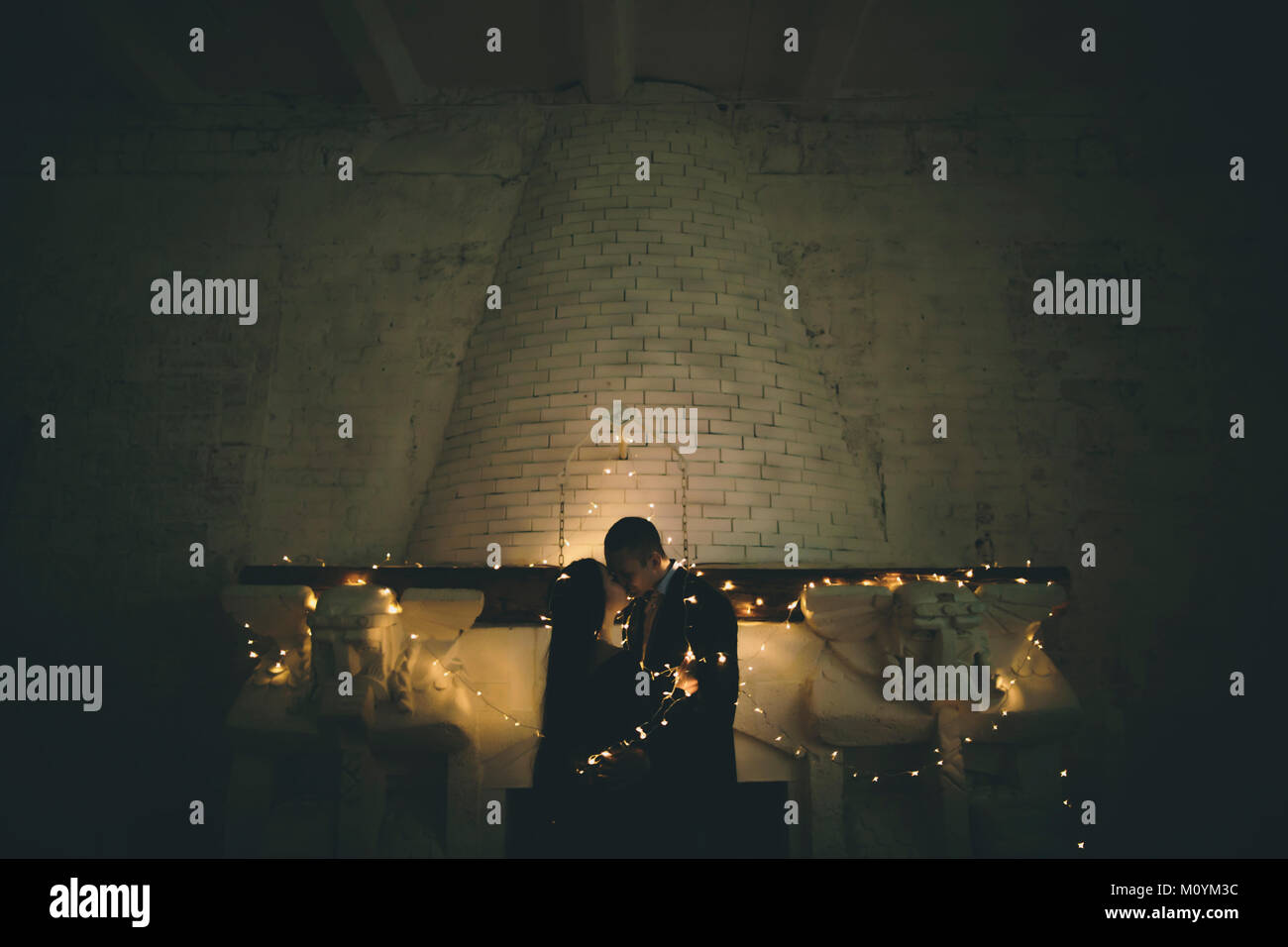 String lights on Caucasian couple near fireplace Stock Photo - Alamy
