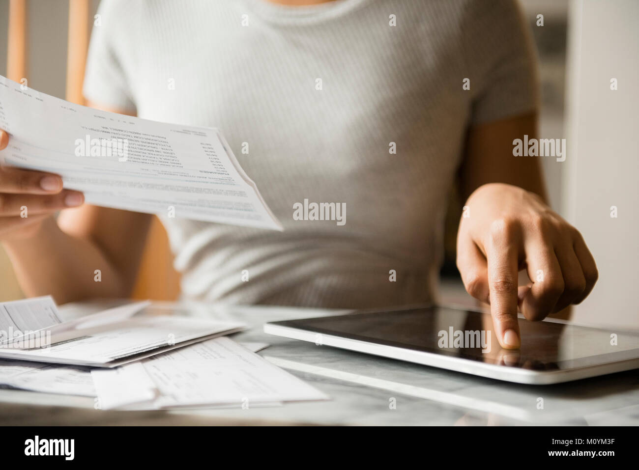 African American woman paying bills with digital tablet Stock Photo