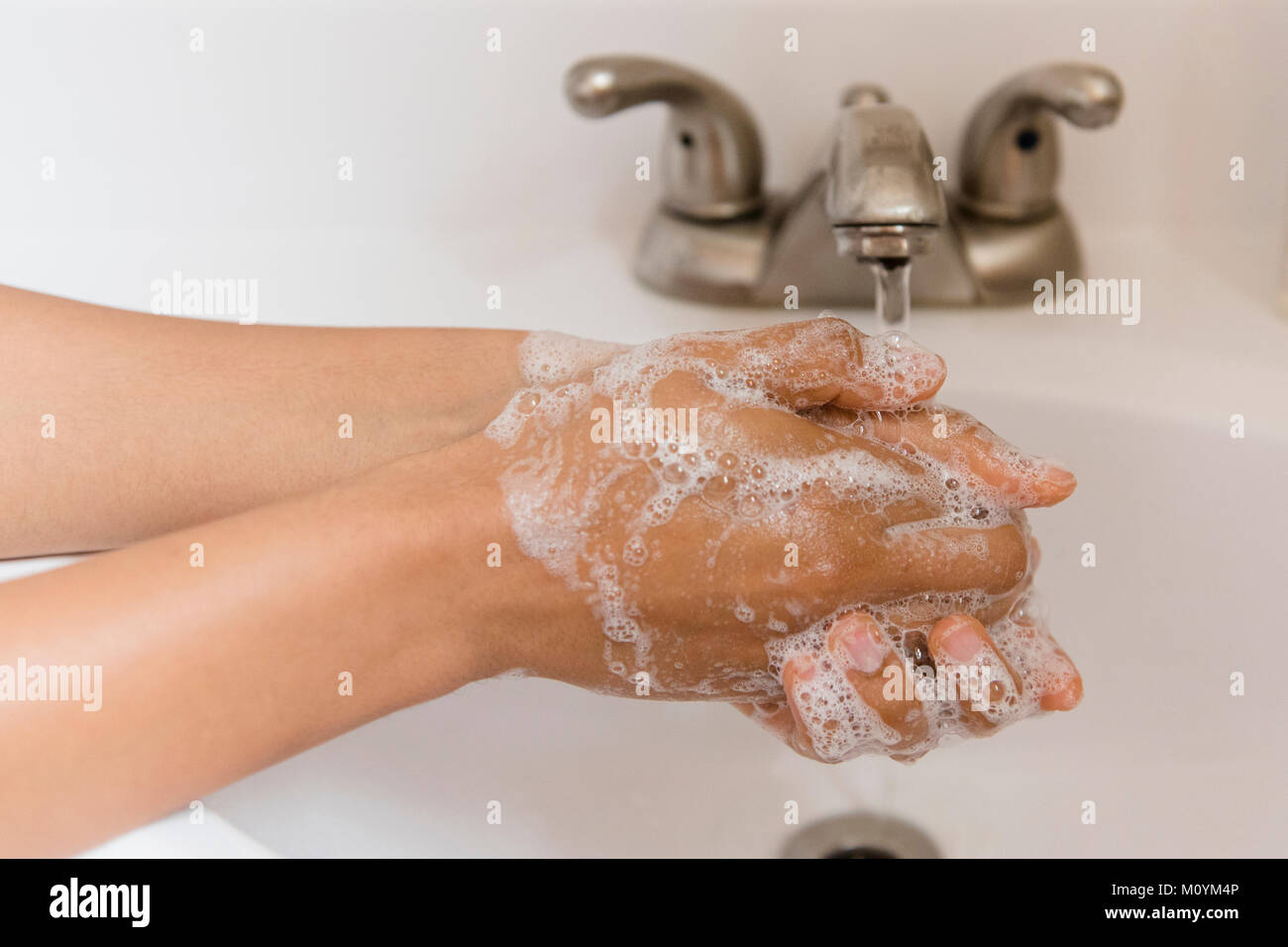 African American woman washing hands with soap Stock Photo