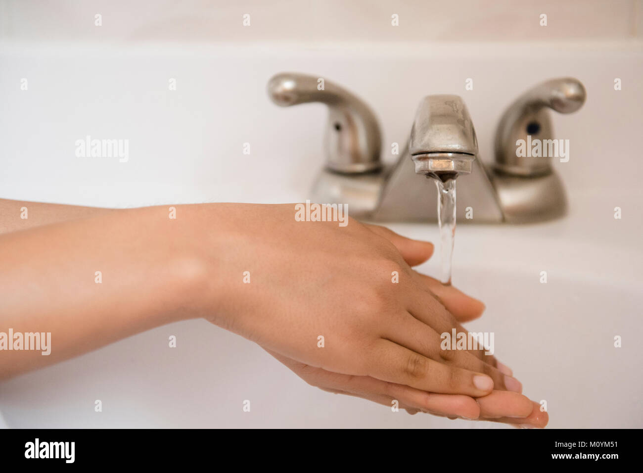 African American woman washing hands with water Stock Photo